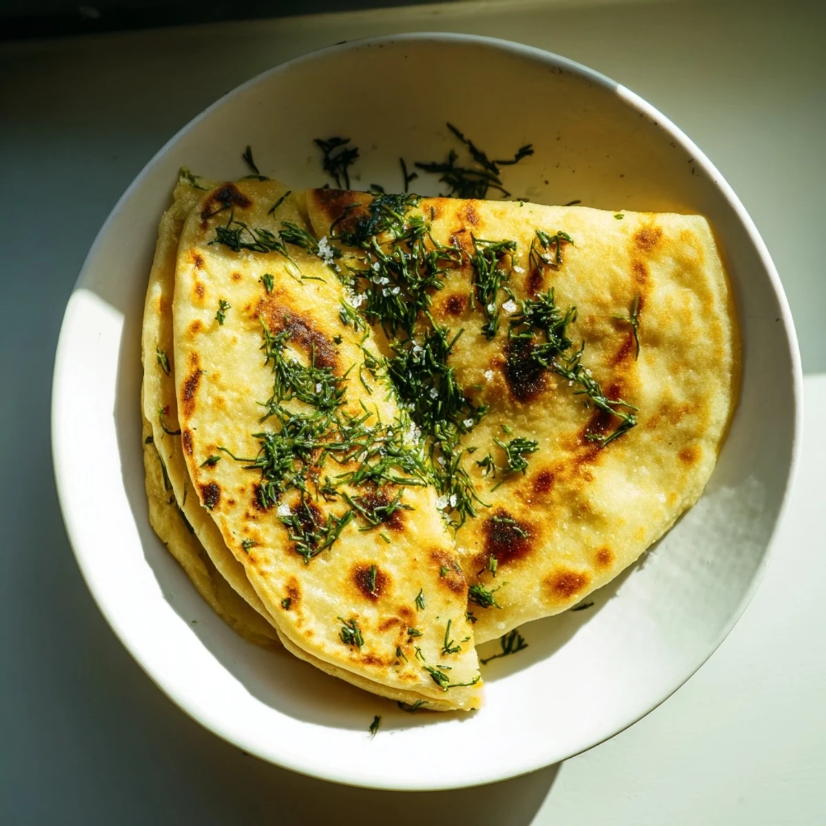 Golden-brown Quick Homemade Flatbread sizzling in a skillet, seasoned with fresh rosemary and sea salt.