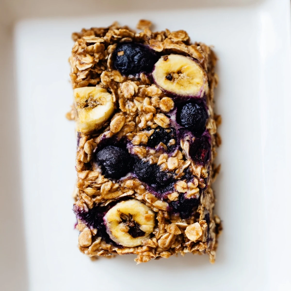 A close-up of a Blueberry Banana Oatmeal Protein Bar with visible blueberries, perfect for a quick breakfast.