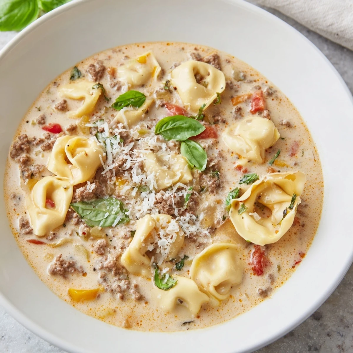 Creamy Tortellini Beef Soup, a comforting Italian-American classic topped with grated Parmesan cheese.