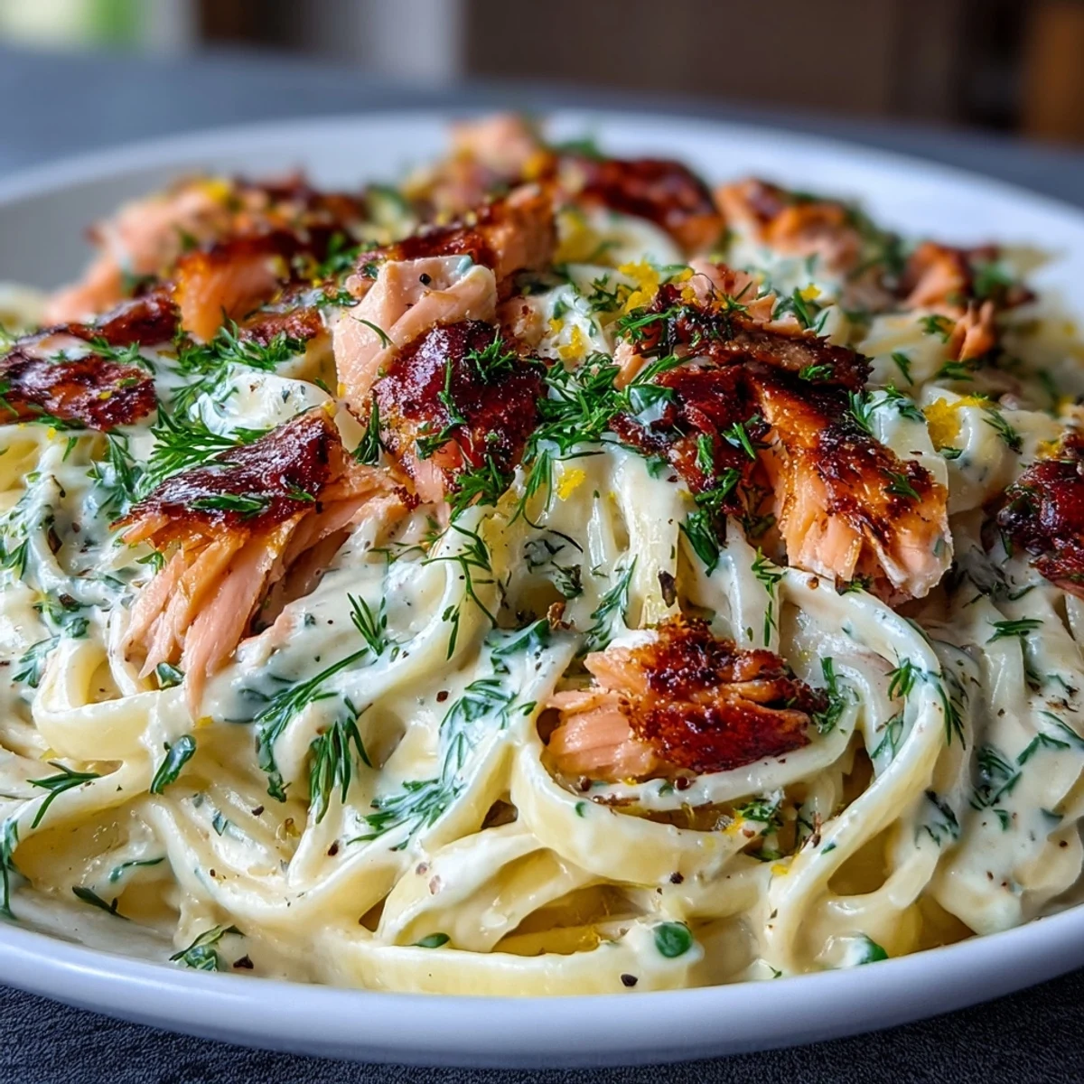Creamy salmon pasta with hot-smoked salmon, fresh dill, and Parmesan in a silky lemon cream sauce, served over fettuccine.  