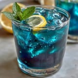 Magical butterfly pea flower lemonade transitioning from blue to purple in a glass.