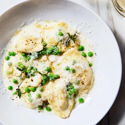 Imagine a vibrant photo of the creamy Parmesan orzo, garnished with bright green peas.