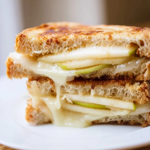 Buttery sourdough embracing creamy Brie and sweet apple slices in this gourmet grilled cheese recipe.