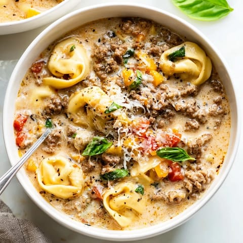A close-up of a rustic bowl of Tortellini Beef Soup, ready to warm up a chilly evening.