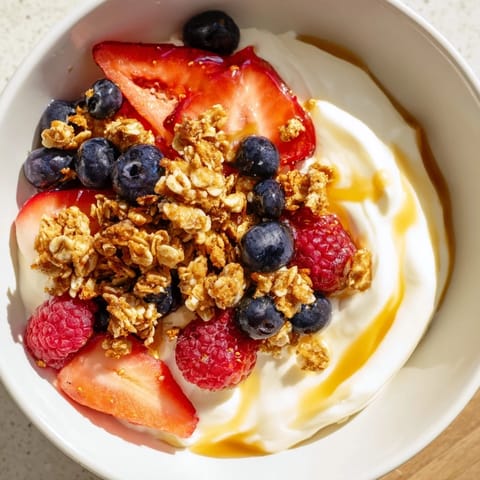 This Cottage Cheese Hot Honey Bowl shows a close-up of creamy cottage cheese with berries, hot honey drizzle, and crunchy granola.