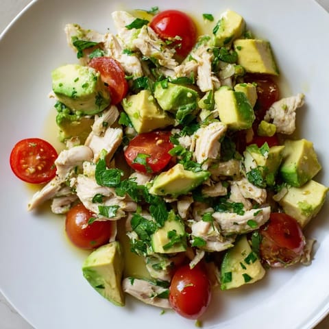 A creamy bowl of Avocado Chicken Salad with tender chicken, crisp cucumber, red onion, and cilantro, ready for a light lunch or picnic.  
