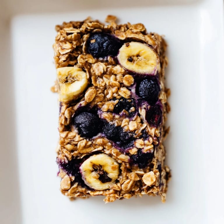 A close-up of a Blueberry Banana Oatmeal Protein Bar with visible blueberries, perfect for a quick breakfast.