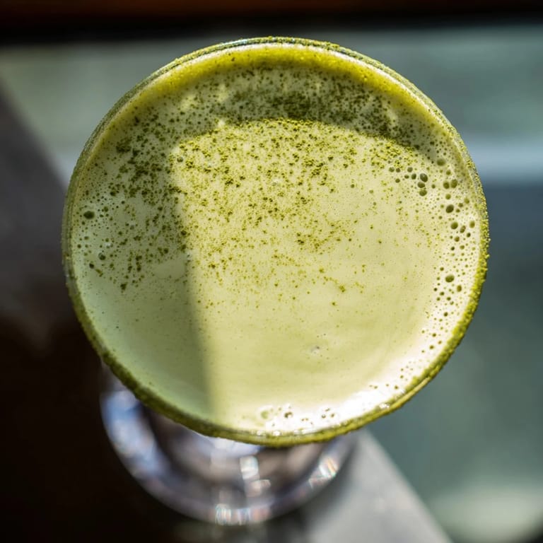 Smooth Matcha Martini Cocktail with creamy layers and a subtle matcha swirl, set against a minimalist kitchen backdrop.