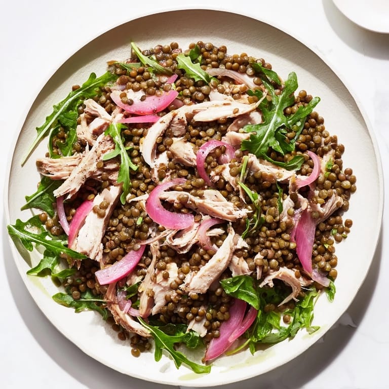 Serving suggestion for Lentil & Chicken Spring Salad, featuring vibrant greens and pickled red onions tossed in a tangy Dijon vinaigrette.